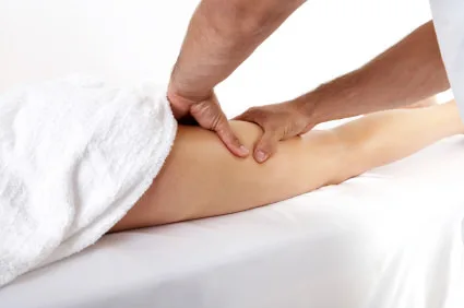 Sportmassage van een kuitspier op de massagetafel